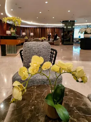 a vase with yellow flowers on a table in a lobby at Shore 2 Reminisce in Manila