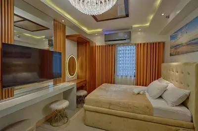 a bedroom with a large television and a bed at Shore 2 Reminisce in Manila
