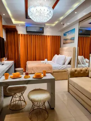 a living room with a bed and a table and chairs at Shore 2 Reminisce in Manila