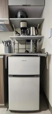 a kitchen with a white refrigerator and a stove at 11a Spacious Suite with Resort Amenities Free Parking with Washer Great for Long Stays in Manila