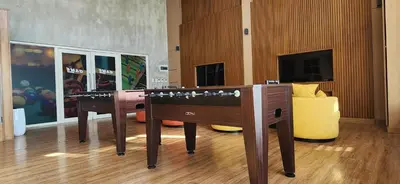 a room with two gaming tables and a yellow couch at 11a Spacious Suite with Resort Amenities Free Parking with Washer Great for Long Stays in Manila