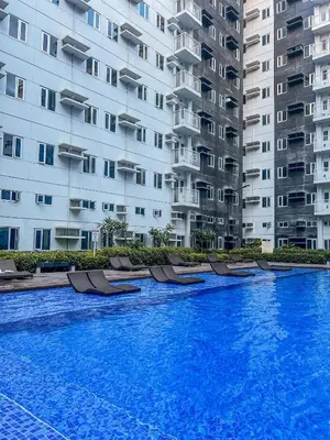 a swimming pool in front of some tall buildings at Addison Place at SMDC Charm in Manila