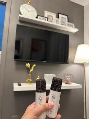 a person holding two electric toothbrushes in a room at Addison Place at SMDC Charm in Manila