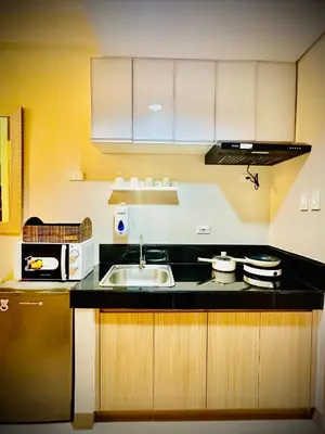 a kitchen with a sink and a microwave at Addison Place at SMDC Charm in Manila