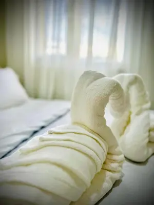 a pile of white towels on a bed at Addison Place at SMDC Charm in Manila
