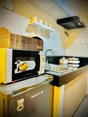 a kitchen with a toaster and a sink at Addison Place at SMDC Charm in Manila