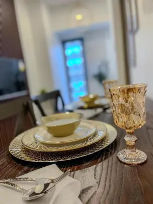 a wooden table with plates and a bowl and a glass at Rejuvenate at Fame Residences Mandaluyong SM MegaMall in Manila
