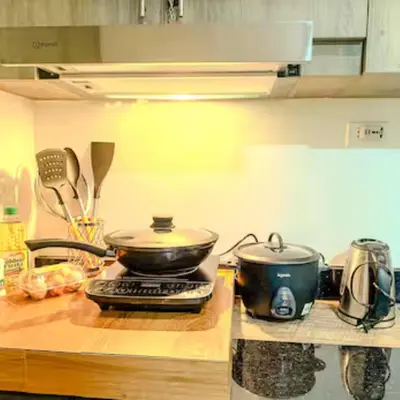 a kitchen counter with two pots and pans on a stove at Rejuvenate at Fame Residences Mandaluyong SM MegaMall in Manila
