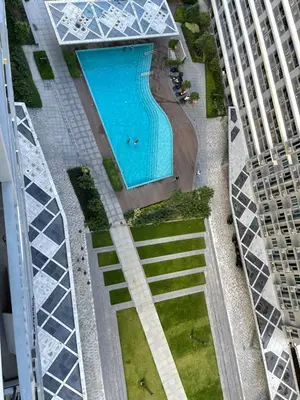 an overhead view of a swimming pool between two buildings at Rejuvenate at Fame Residences Mandaluyong SM MegaMall in Manila