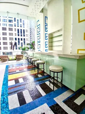 a lobby with a bar with stools in a building at 1BR in Makati Prime Location in Manila