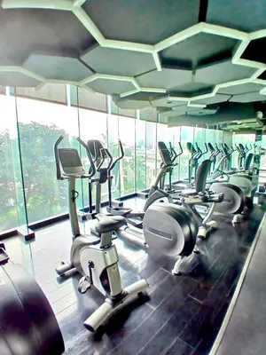 a gym with a row of cardio machines at 1BR in Makati Prime Location in Manila