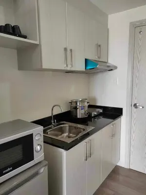 a kitchen with a sink and a microwave at Casa Relajante at Recto Manila in Manila