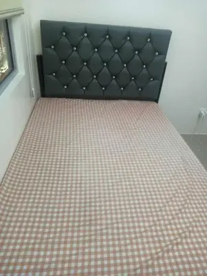 a bed with a checkered mattress and a black headboard at Deca Cubao Tower Budget Condo by Ashti in Manila