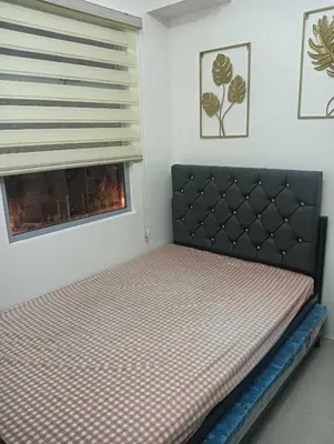 a small bedroom with a bed with a window at Deca Cubao Tower Budget Condo by Ashti in Manila