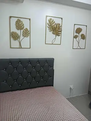 a bedroom with a bed and three pictures on the wall at Deca Cubao Tower Budget Condo by Ashti in Manila