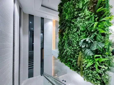 a vertical green wall in a hallway with a staircase at 1BR Condotel Suite at Sunshine100 City Plaza #SS01-1 in Manila