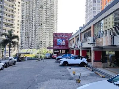 a parking lot with cars parked in front of tall buildings at 1BR Condotel Suite at Sunshine100 City Plaza #SS02-1 in Manila