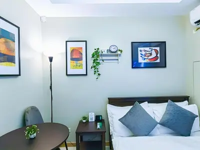 a bedroom with a bed and a table and pictures on the wall at 1BR Condotel Suite at Sunshine100 City Plaza #SS03-1 in Manila