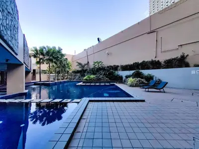 a swimming pool with a bench next to a building at 1BR Condotel Suite at Sunshine100 City Plaza #SS04-1 in Manila