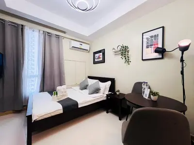 a bedroom with a bed and a table and a chair at 1BR Condotel Suite at Sunshine100 City Plaza #SS05-1 in Manila