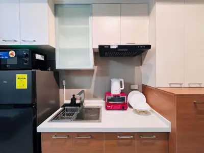 a kitchen with a sink and a black refrigerator at 1BR Condotel Suite at Sunshine100 City Plaza #SS06-1 in Manila