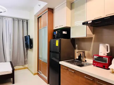 a kitchen with a black refrigerator and a sink at 1BR Condotel Suite at Sunshine100 City Plaza #SS06-1 in Manila