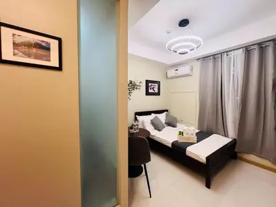 a bedroom with a bed and a desk in a room at 1BR Condotel Suite at Sunshine100 City Plaza #SS06-1 in Manila