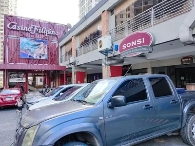 a blue pick up truck parked in front of buildings at 1BR Condotel Suite at Sunshine100 City Plaza #SS06-1 in Manila