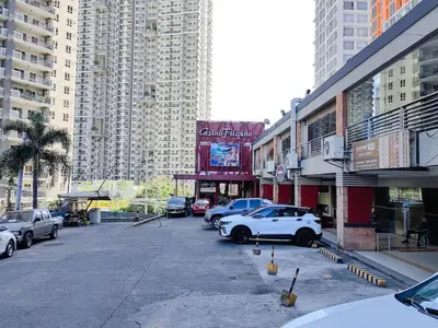 a parking lot with cars parked in front of tall buildings at 1BR Condotel Suite at Sunshine100 City Plaza #SS07-1 in Manila
