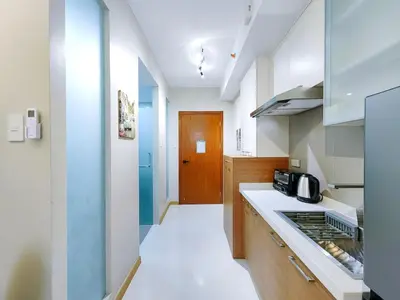 a kitchen with a stove top oven next to a counter at 1BR Condotel Suite at Sunshine100 City Plaza #SS07-1 in Manila