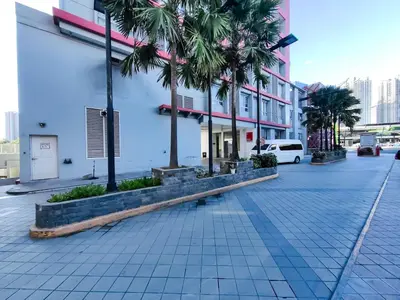 a street with palm trees in front of a building at 1BR Condotel Suite at Sunshine100 City Plaza #SS07-1 in Manila