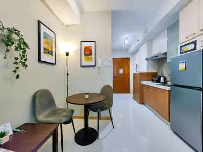 a kitchen with a table and two chairs and a refrigerator at 1BR Condotel Suite at Sunshine100 City Plaza #SS07-1 in Manila