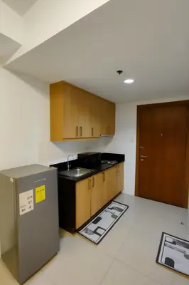 an empty kitchen with a sink and wooden cabinets at Very Spacious Condo at Mall of Asia in Manila