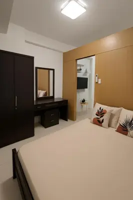 a bedroom with a large bed and a mirror at Very Spacious Condo at Mall of Asia in Manila