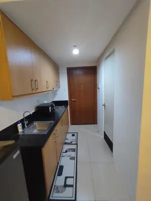 a small kitchen with a sink and a stove at Very Spacious Condo at Mall of Asia in Manila
