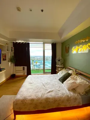 a bedroom with a large bed with a view of the ocean at Azure staycation by scarlet suites in Manila