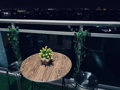 a table with a potted plant on a balcony at Azure staycation by scarlet suites in Manila