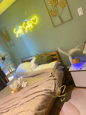 a bedroom with a bed with a neon sign on the wall at Azure staycation by scarlet suites in Manila