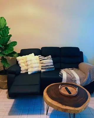 a living room with a black couch and a coffee table at Studio 12LVE in Manila