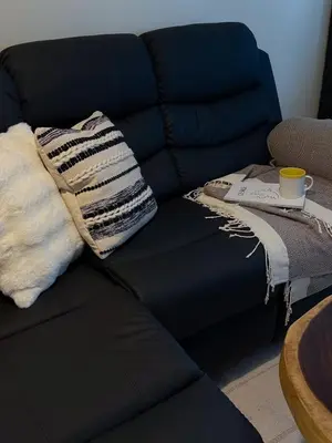 a blue couch with two pillows and a cup of coffee at Studio 12LVE in Manila