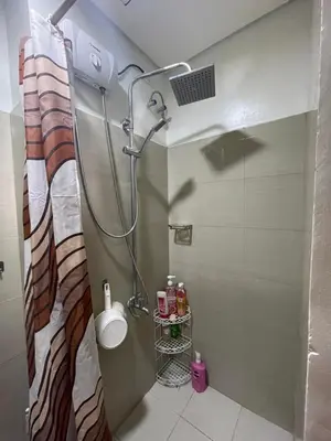 a bathroom with a shower with a sink and a toilet at Myras aesthetic unit in Manila