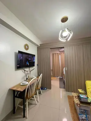 a living room with a table and chairs and a television at Myras aesthetic unit in Manila