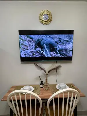 a table with two chairs and a tv on a wall at Myras aesthetic unit in Manila