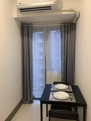 a table with two plates on it in front of a window at Fame Tower 2 Luxury Queen with own Washer in Manila