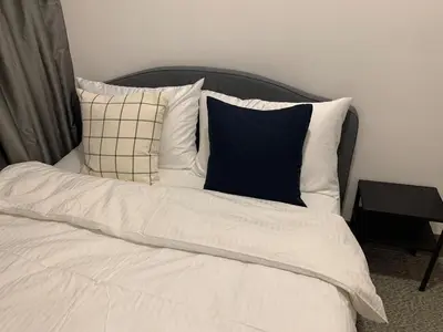 a bed with white sheets and pillows on it at Fame Tower 2 Luxury Queen with own Washer in Manila