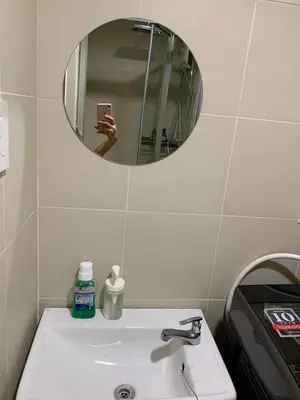 a bathroom sink with a mirror and a person taking a picture at Fame Tower 2 Luxury Queen with own Washer in Manila