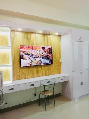 a room with a desk and a painting on the wall at S Suite Home MOA Staycation in Manila
