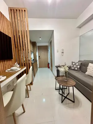 a living room with a couch and a table at Lush Residences 1Br Haven Suite Makati Smart TV Netflix Hi speed internet in Manila