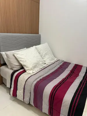 a bed with a striped blanket and two pillows at Lush Residences 1Br Haven Suite Makati Smart TV Netflix Hi speed internet in Manila