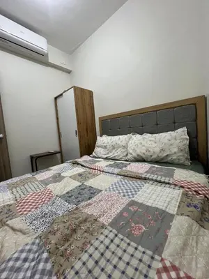 a bedroom with a bed with a quilt on it at Key and Stay in Manila